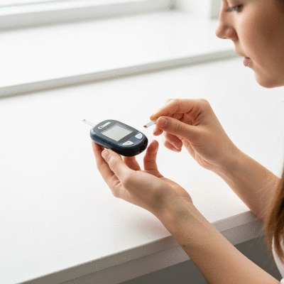 Person checking blood sugar with a meter and finger prick, close-up, natural light